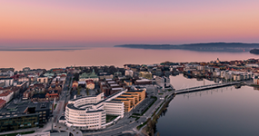 Drone photo of campus with Jönköping and lake Vättern in the background during sun set